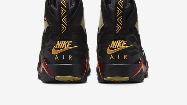 Rear view of black and gold Air Jordan shoes.